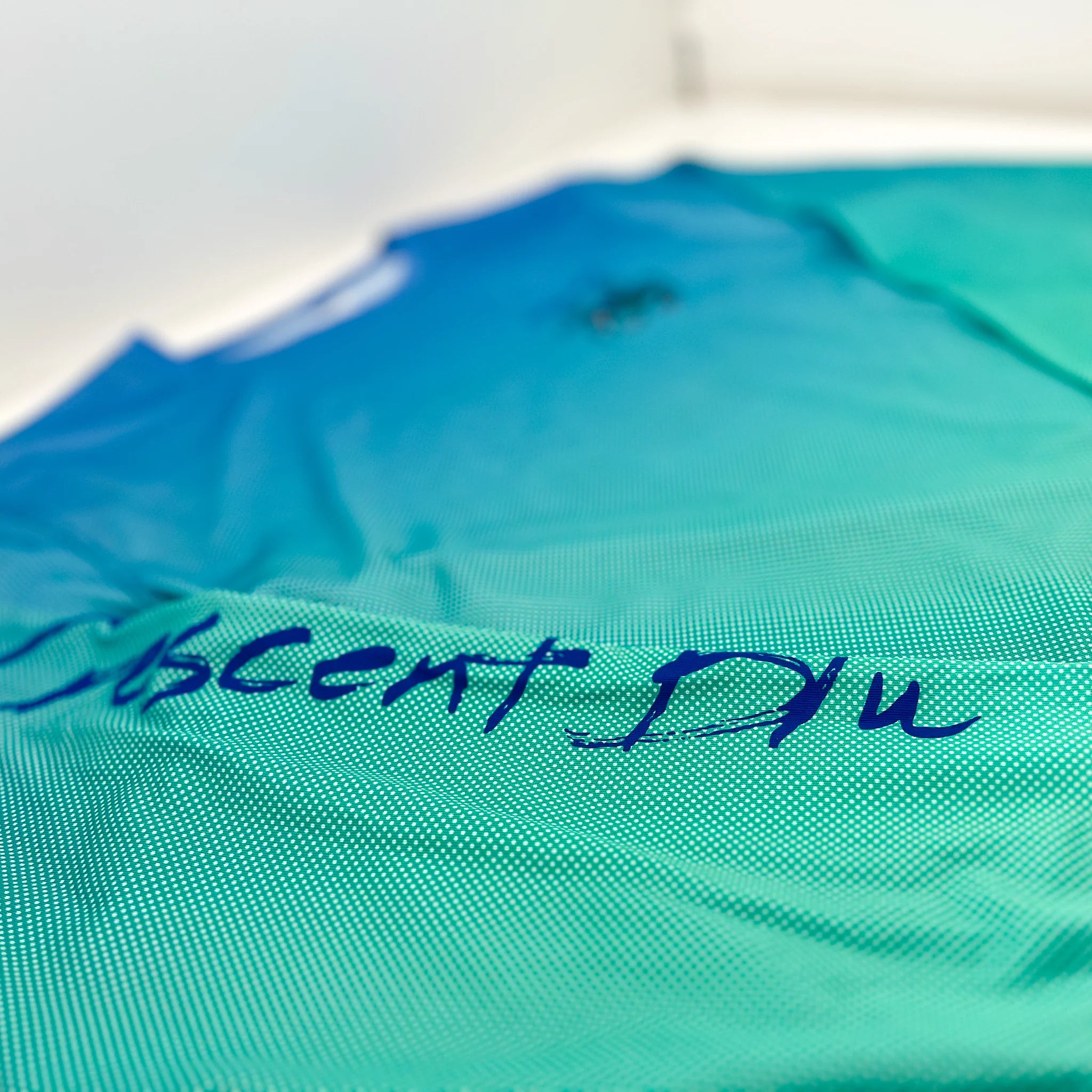Close up of the right sleeve with "Crescent Blu" written on it. You can see the dot gradient pattern of the fabric.
