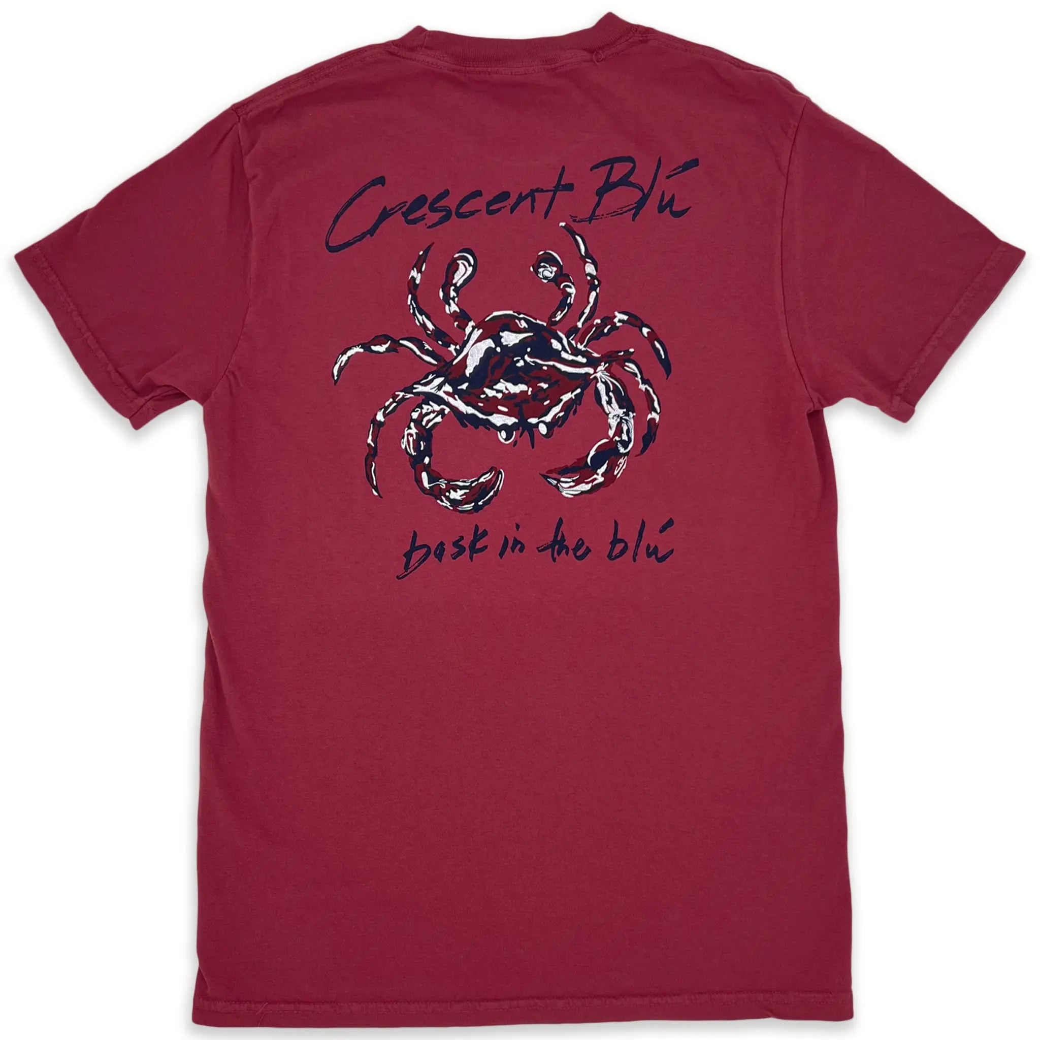 The back of a red t-shirt. Crescent BLú is written above a crimson, navy, and white crab. Bask in the blu is written below the crab.