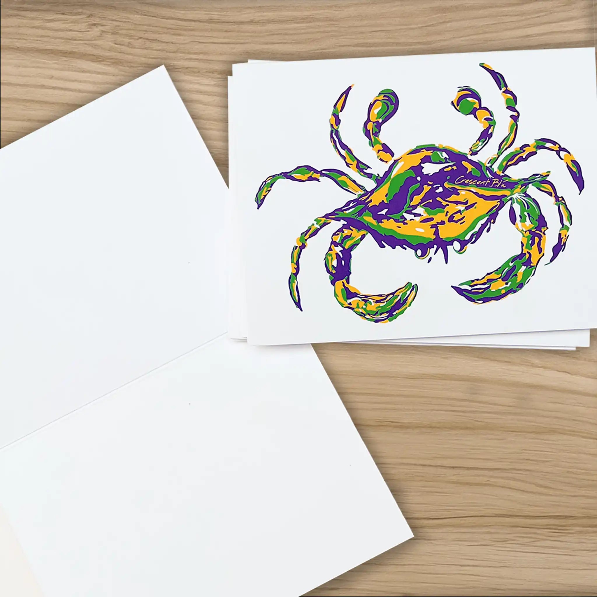 Crescent Blu Mardi GRas Crab notecards on the a wooden desk.