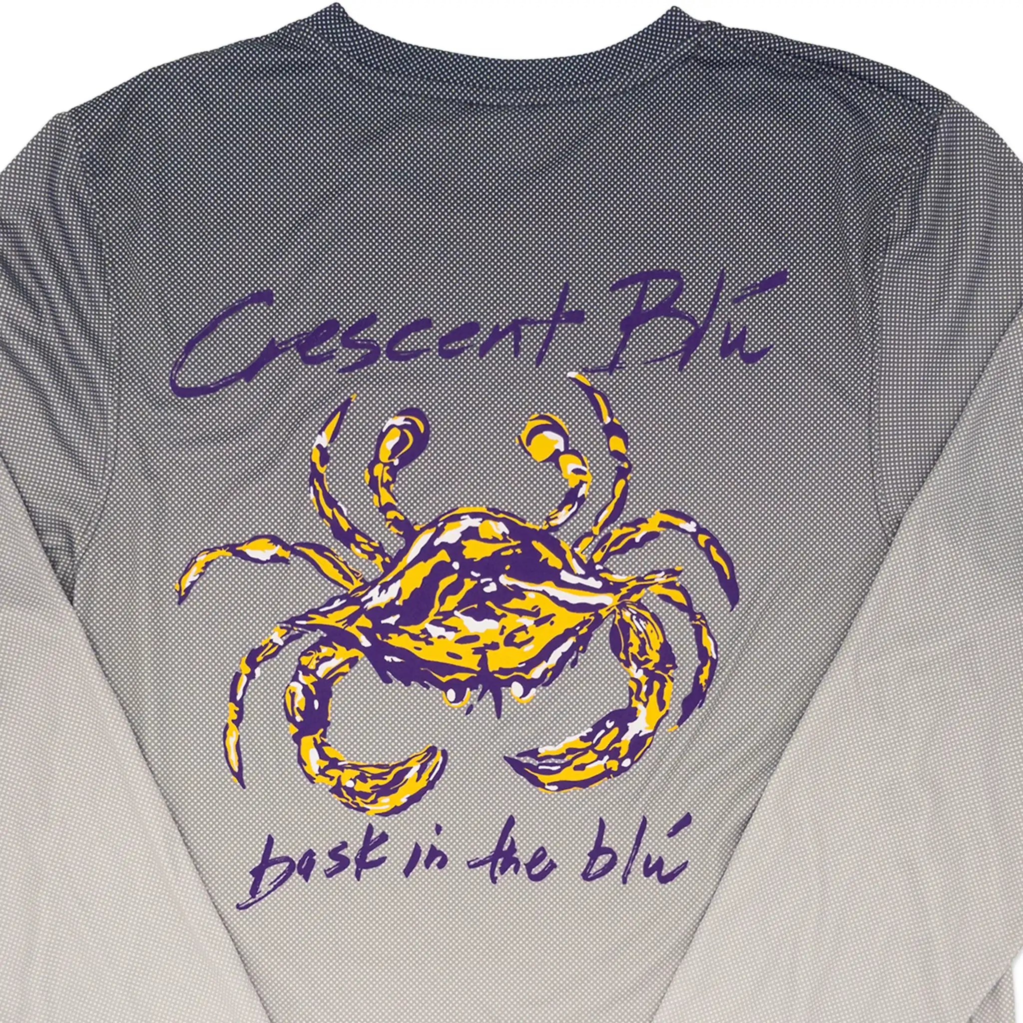 Close-up of the back of a gray long-large yellow and purple crab graphic and the words 'Crescent Blu' and 'bask in the blue' printed on it