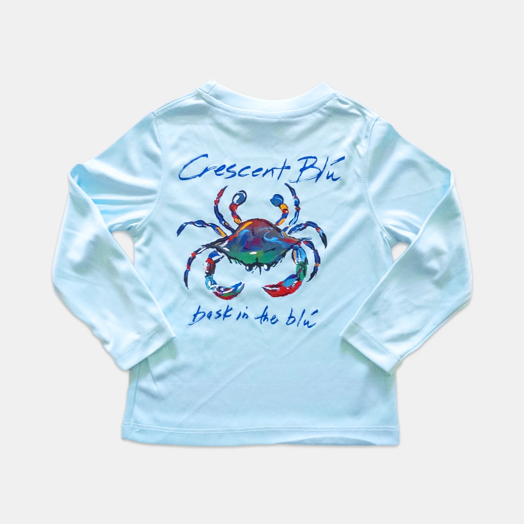 A light blue long-sleeve toddler shirt shown crab graphic and the text 'Crescent Blu' and 'bask in the blu' printed on the back