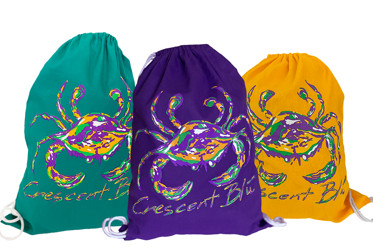 A green, a purple, and a gold Mardi Gras drawstring bags with a Mardi Gras crab on them. 