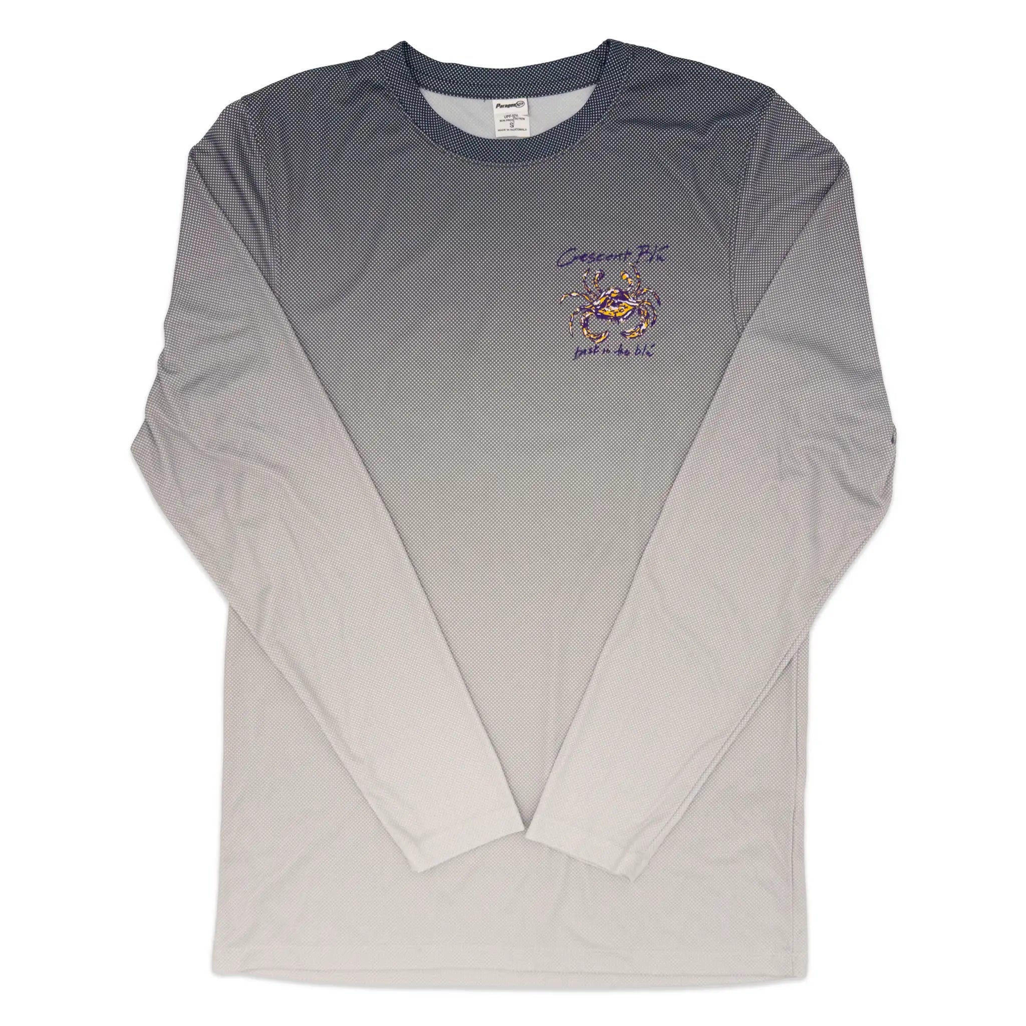 A long-sleeve sun shirt shirt with a gray-to-white ombre gradient, featuring a small purple and gold crab on the left chest